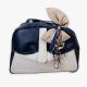 Premium χειροποίητη τσάντα βάπτισης, σε μπλε χρώμα με μπεζ καπιτονέ λεπτομέρειες. Είναι διακοσμημένη με υπέροχη υφασμάτινη σύνθεση σε σοκολά αποχρώσεις και ξύλινα διακοσμητικά κορωνάκια.
